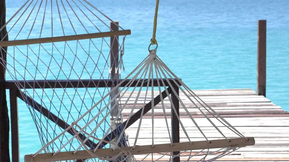 Stabhängematte aus Kordel an einem Holzsteg am Meer